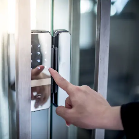man pressing keypad to access a commercial office after lockout